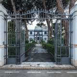 A introdurla � un elegante cancello nero incastonato tra due alte colonne in pietra di tufo che riportano il nome dell�edificio...